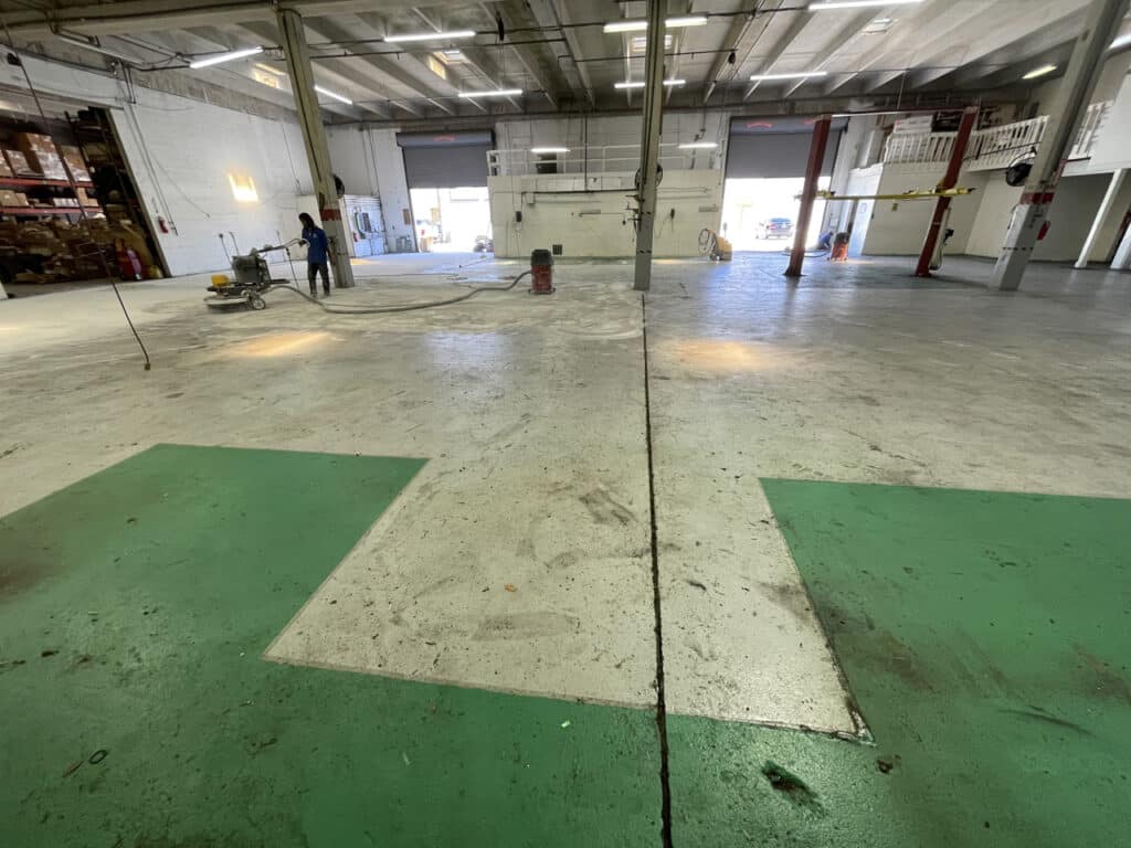 Epoxy flooring in John Deere warehouse with logo installation - Boynton Beach, FL